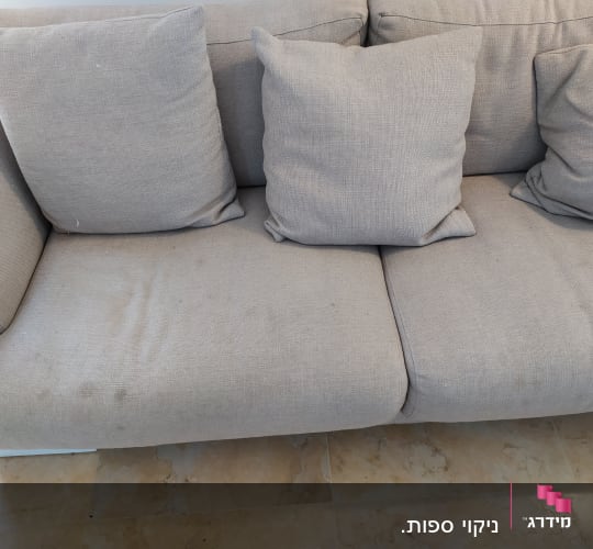 ספה אפורה עם כתמים על המושב